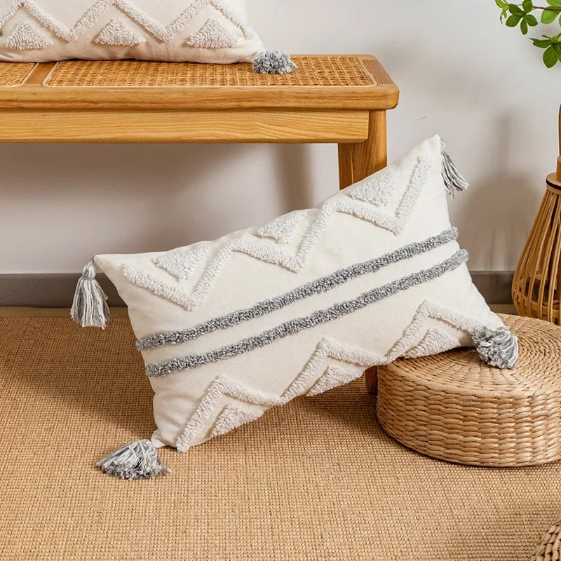 Funda de cojín DecorBites™ con borlas geométricas y mechones, blanca y gris, estilo bohemio.