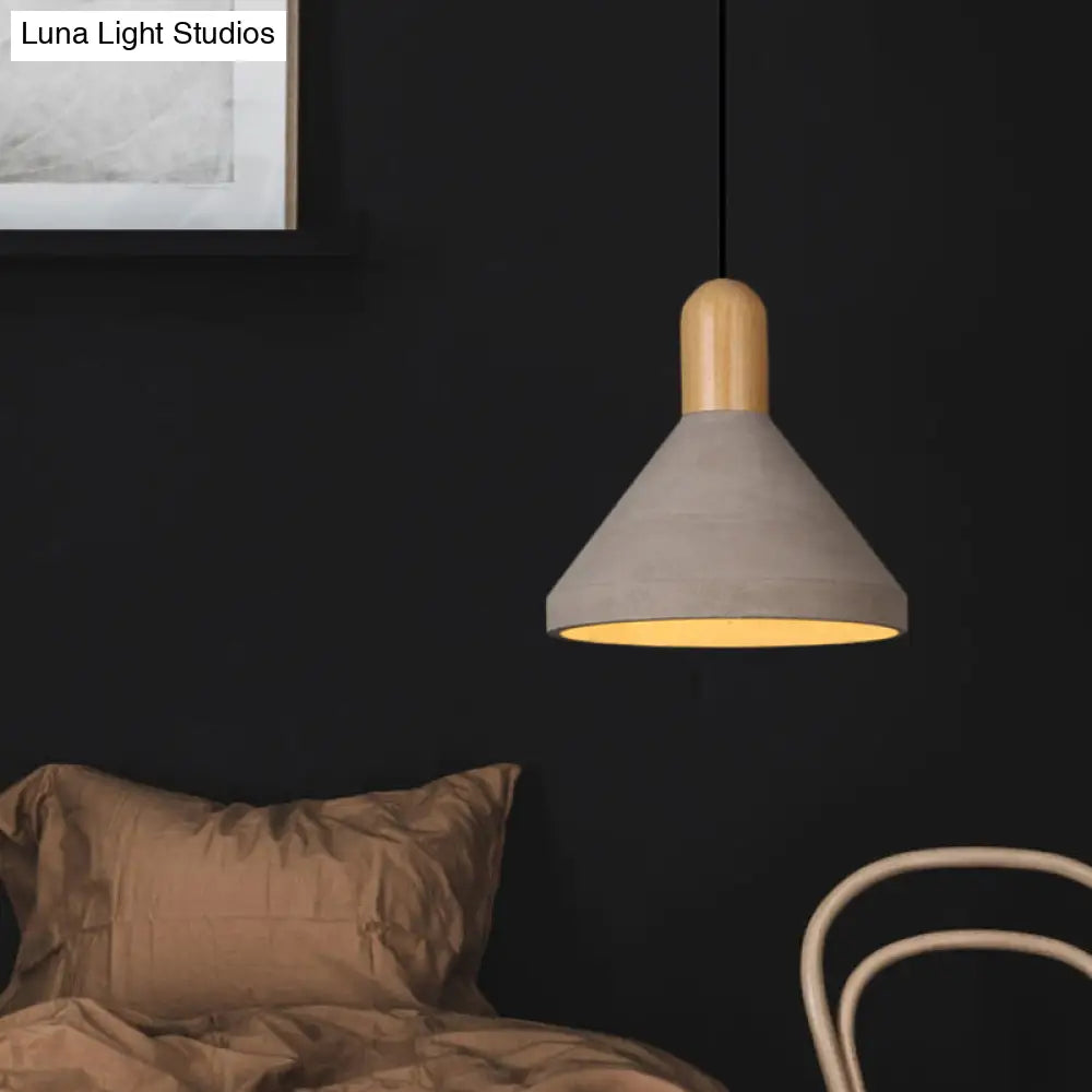 Lámpara colgante de techo cónica de cemento envejecido para restaurante, en gris con detalles de madera.