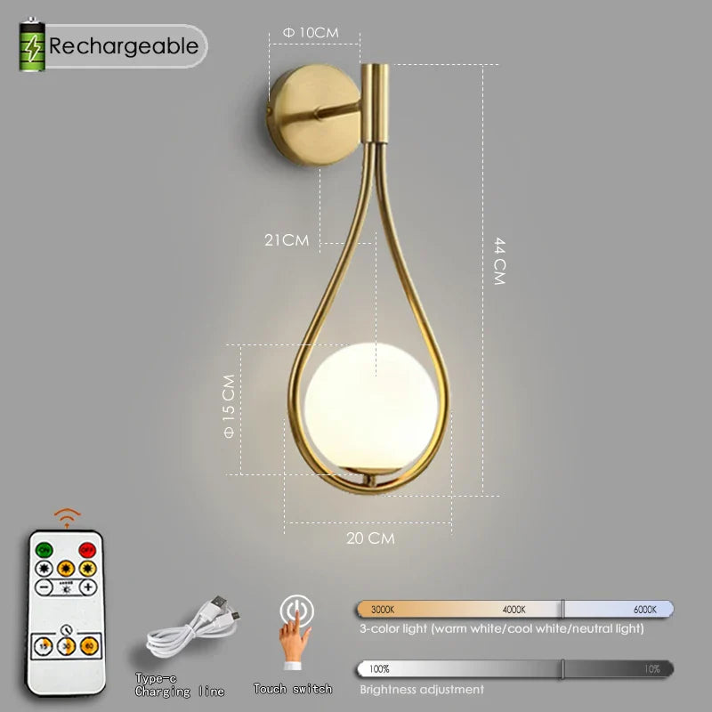 Gold teardrop wall sconce with a spherical light.