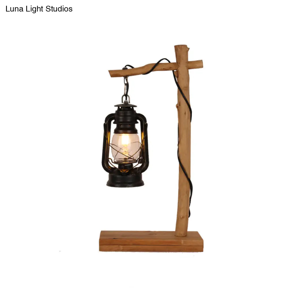 Lámpara de mesa de noche de cristal negro con soporte en cruz de madera.