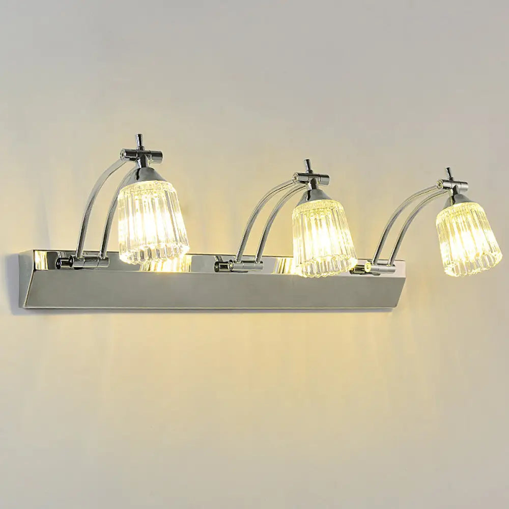 Lámpara de tocador contemporánea DecorBites™ de cristal: pantallas de cristal transparente acanaladas, acabado plateado, 3 cabezales, luz cálida/blanca.