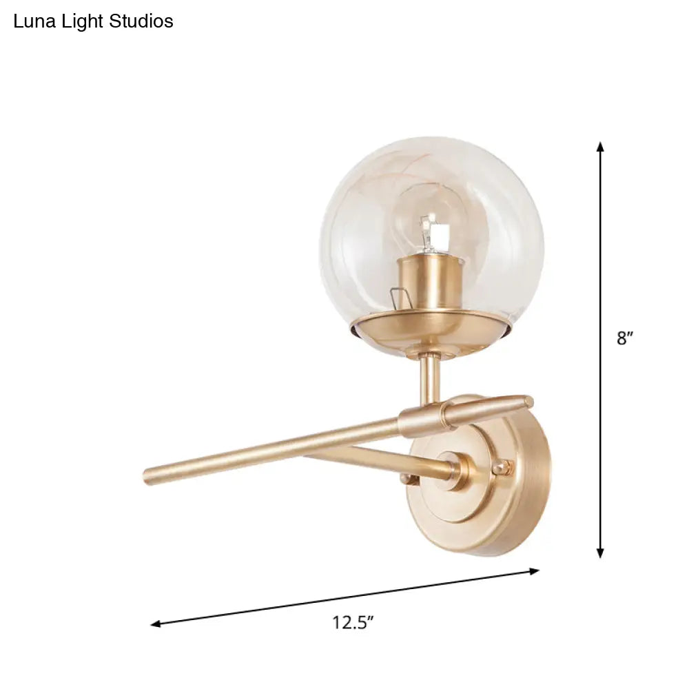 DecorBites™ DecorBites™ Contemporary Hand Blown Glass Wall Light with Brass Globe and Crossed Arm