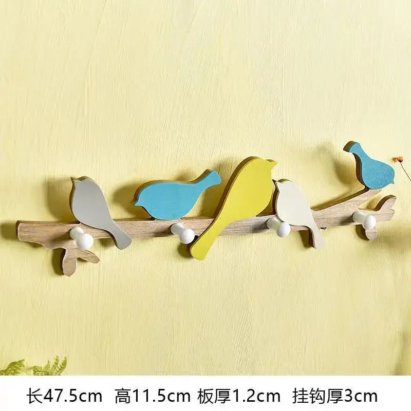 Wooden green and beige coat rack with five painted birds in gray blue and yellow and white spherical hooks decorbites birds coat rack
