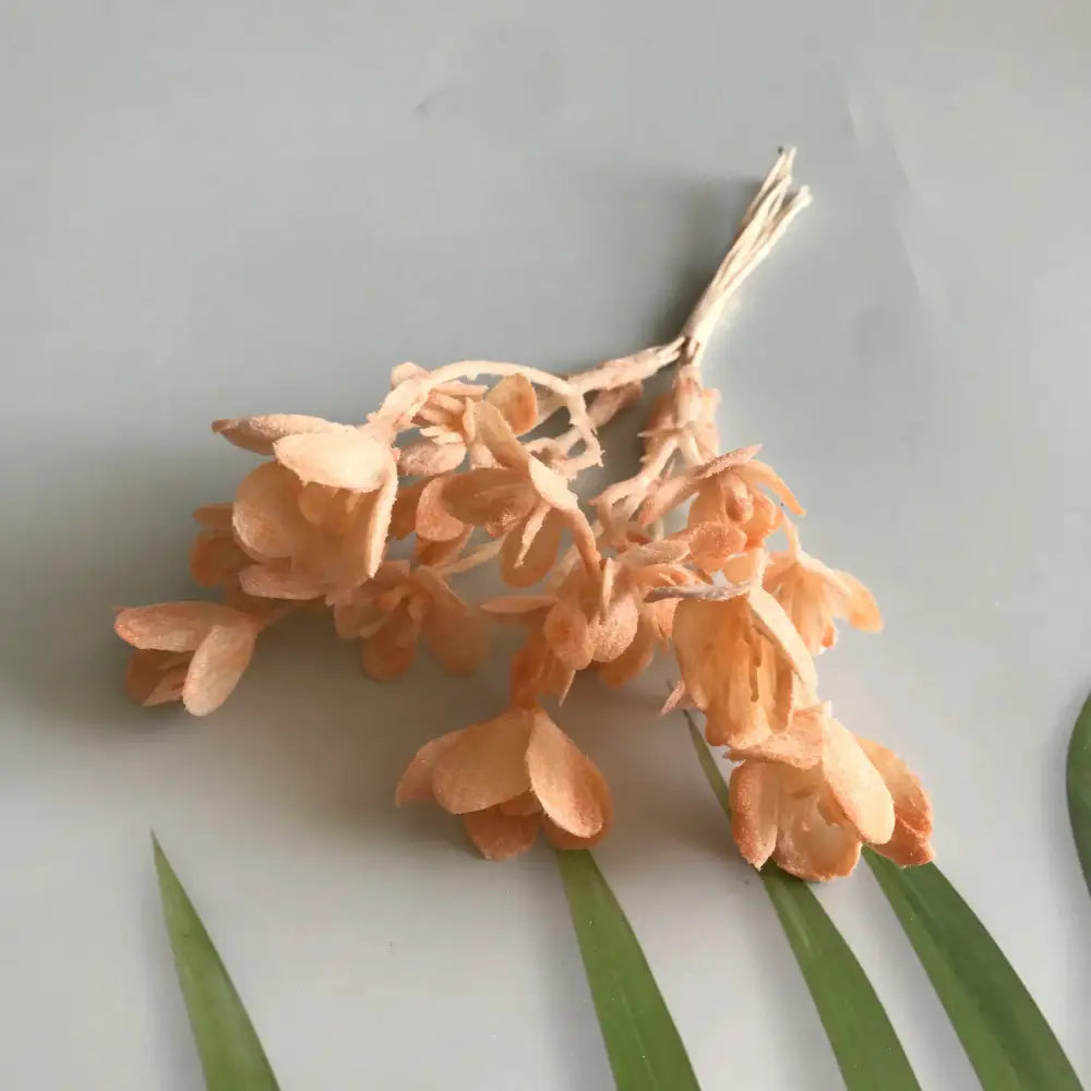 A delicate cluster of peach-colored artificial plants with slender stems from decorbites artificial plants green grass collection