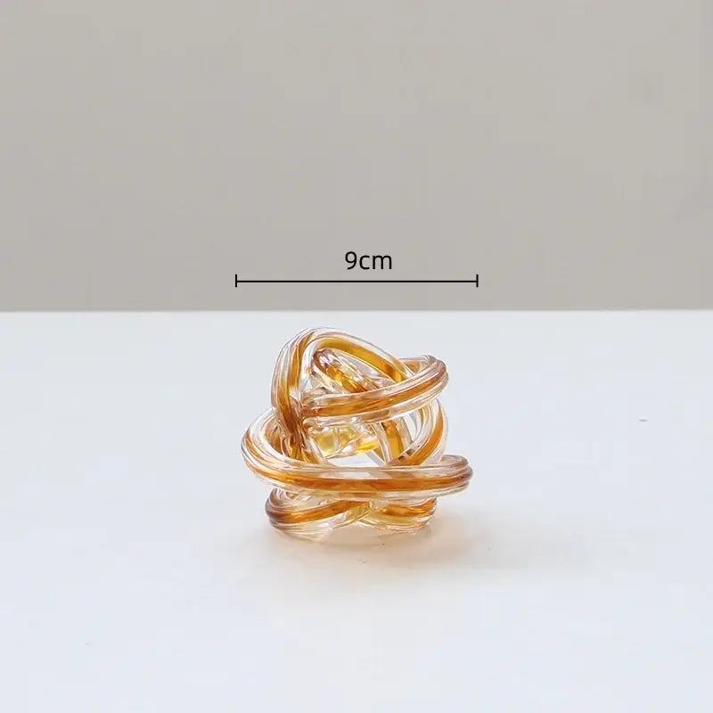 A translucent amber glass geometric wound ring with a twisted twine sphere design for decorbites living room decor