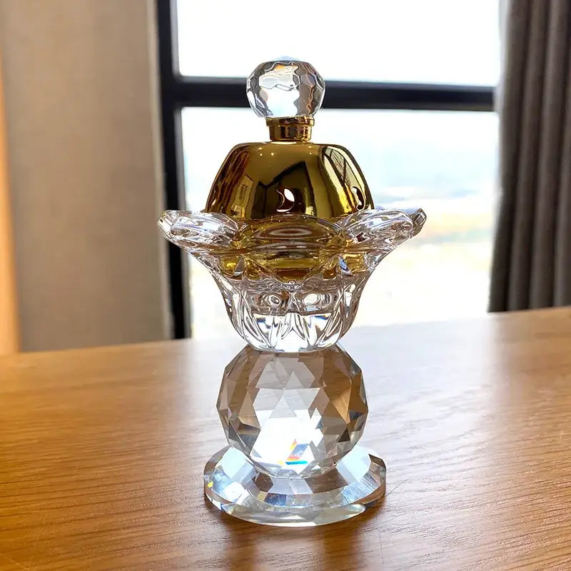 Gold crystal candle holder and metal incense burner featuring a crystal skull perfume bottle with gold cap and faceted base