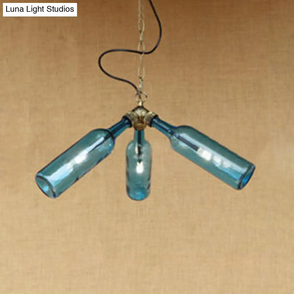 Lámpara de araña de estilo industrial con tres luces, hecha con botellas de vidrio y diseño de tuberías, en negro y transparente.