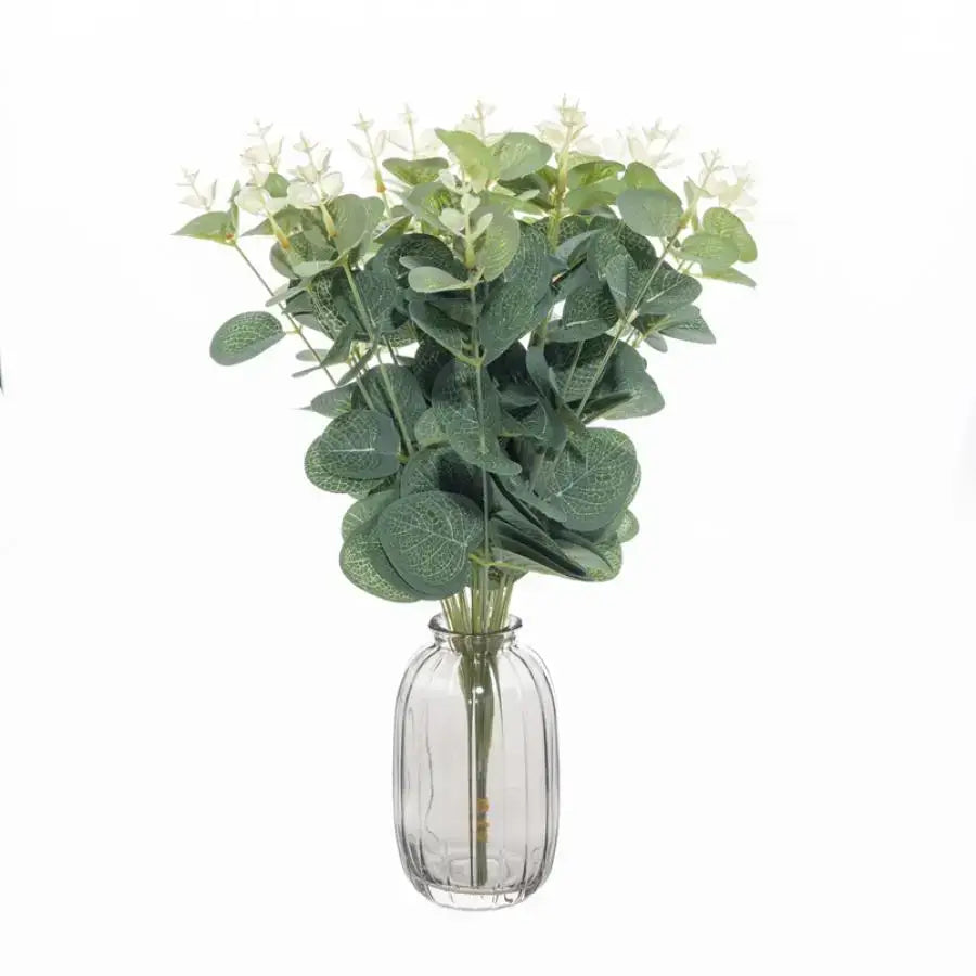 Lush artificial eucalyptus leaves garland with green leaves and white flowers in a clear glass vase for decorbites decor