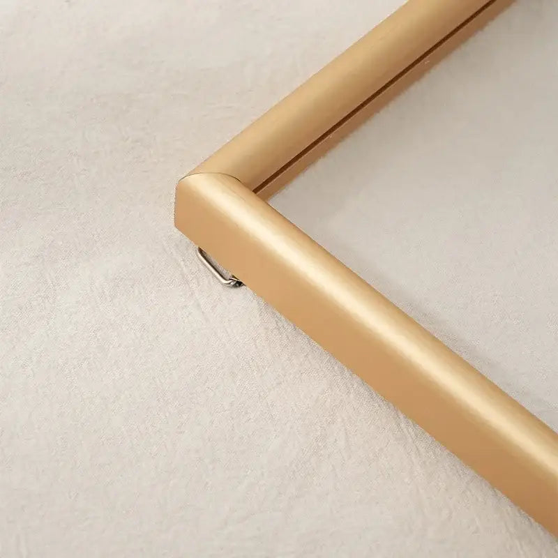 Gold-colored sleek metal hangable picture frame corner with matte finish and beveled edges for minimalist bedroom art