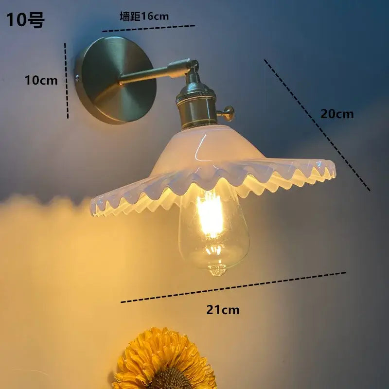 Modern brass wall sconce with decorbites clear glass ruffled off-white shade and clear glass led filament bulb