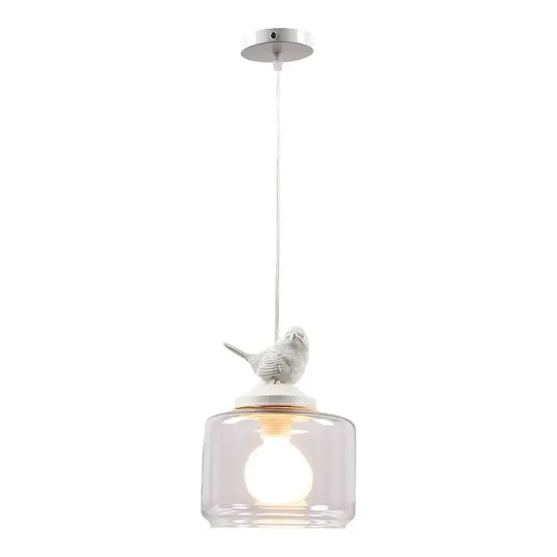 A white ceramic decorbites bird perched on a clear glass pendant of a bird led glass chandelier dining room light