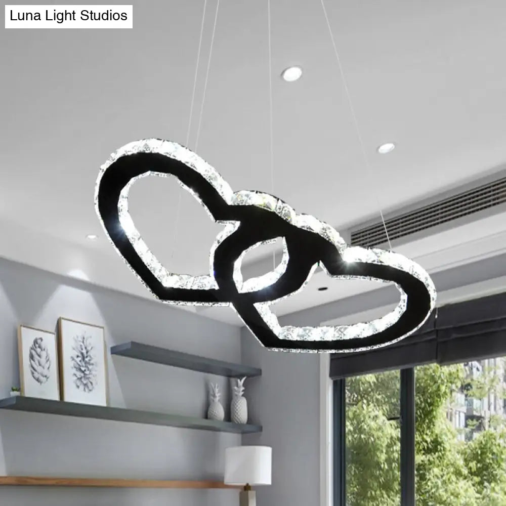 Lámpara de araña colgante LED moderna con forma de doble corazón, cristal transparente, pantalla negra y luz cálida/blanca.