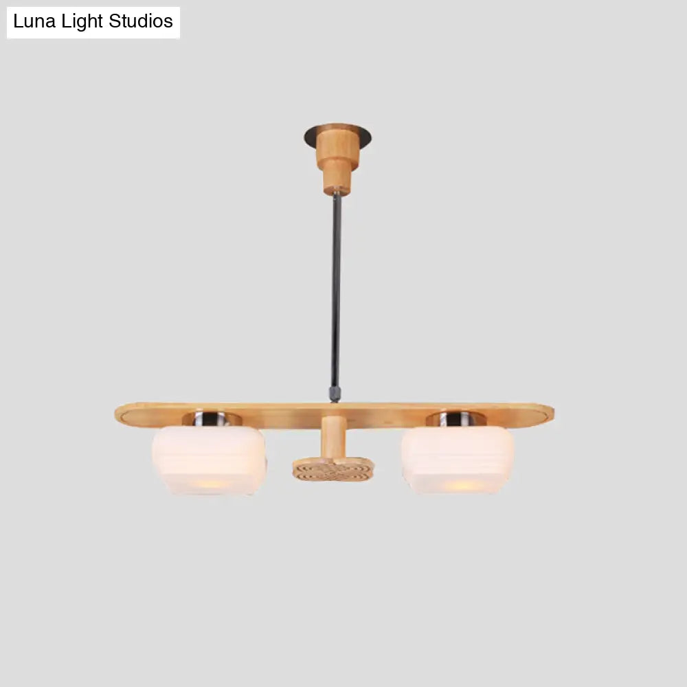 Lámpara colgante moderna de madera con dos pantallas cuadradas de cristal color crema para el techo del comedor.