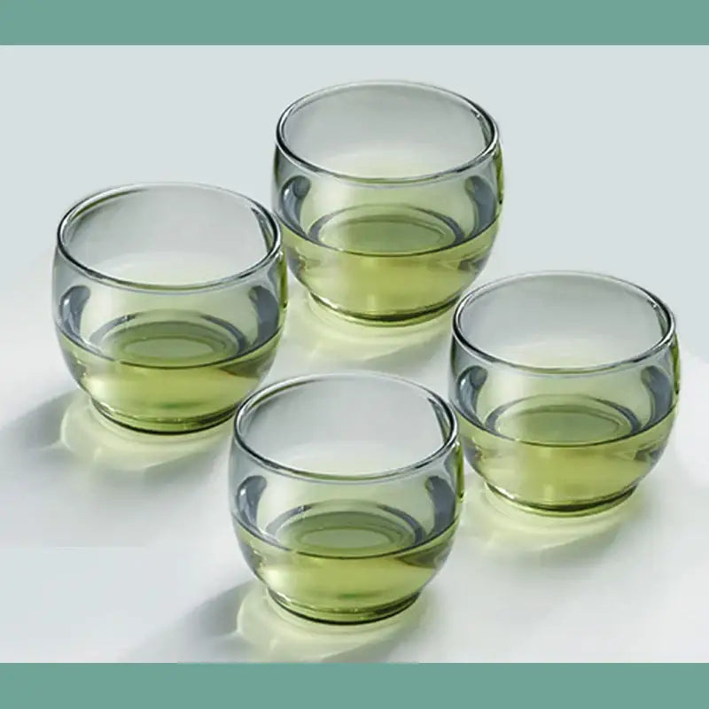 Set of four translucent olive green glass tea cups with rounded bowl shape and clear rims for kung fu tea decorbites glass tea