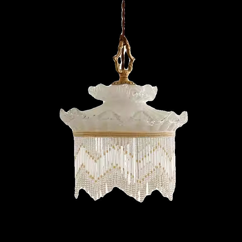 Cream-colored beaded chandelier with a scalloped edge and brass accents.