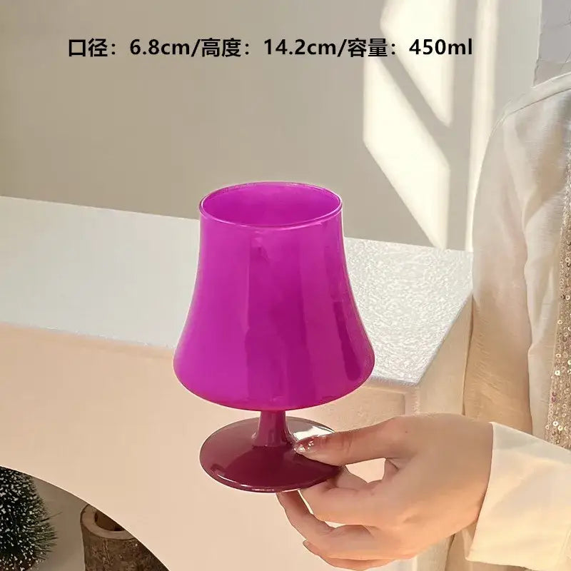 Vibrant magenta plastic decorbites gem champagne coupe glass with flared bowl and stem held in hand