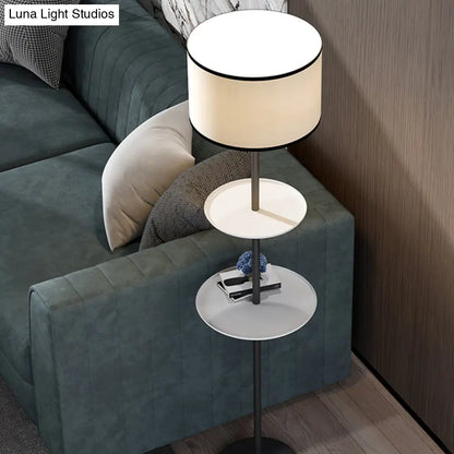 مصباح أرضي حديث أسطواني أسود بمصباح واحد مع أرفف وغطاء من القماش