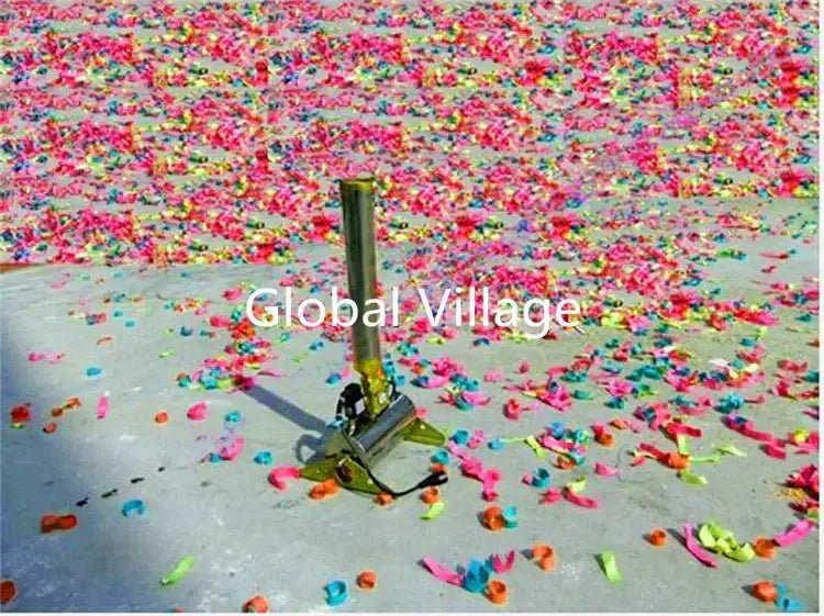 A metallic cylindrical 150w confetti machine with black handle stands upright amid colorful paper confetti for wedding decor