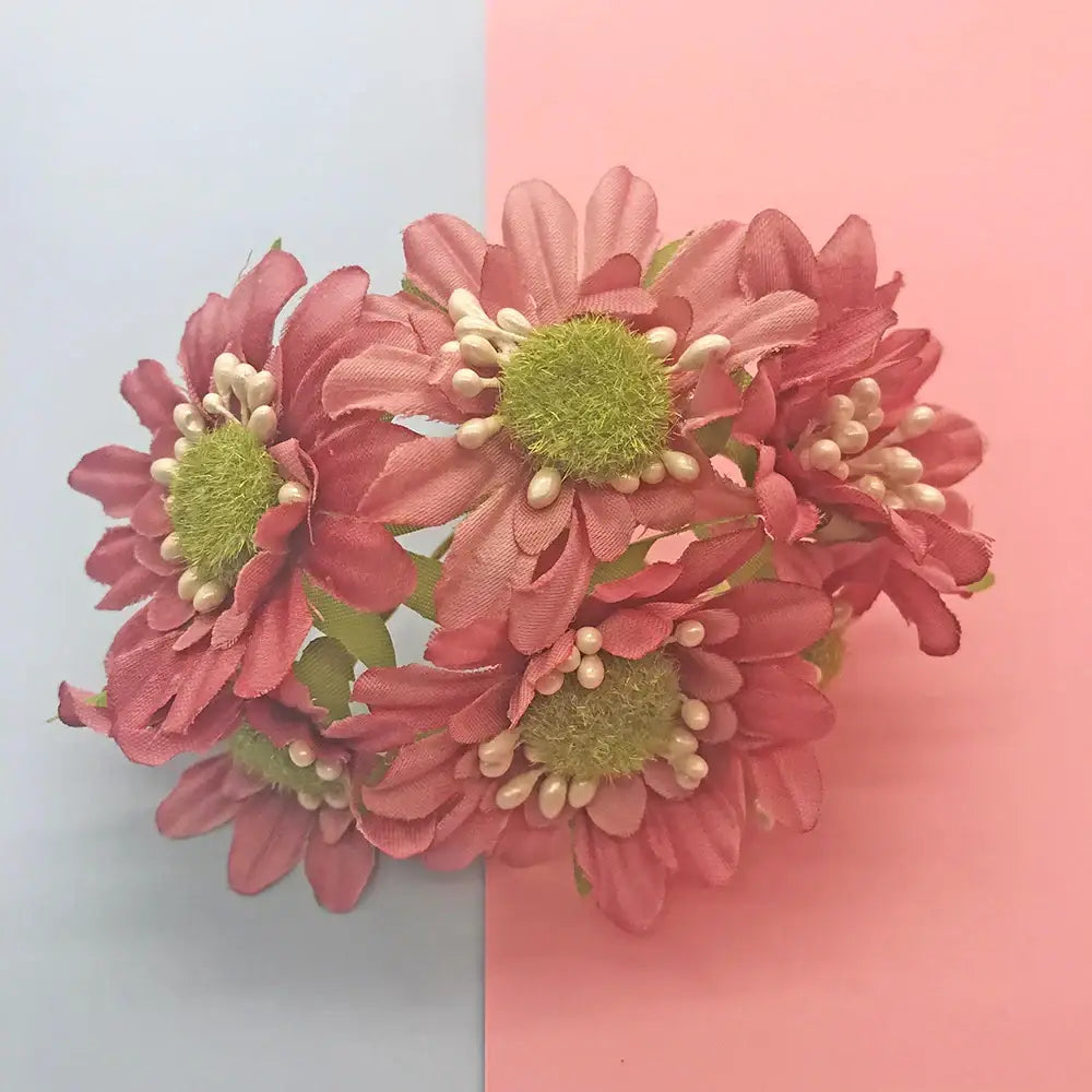 A cluster of pink fabric daisies with green centers and white bead accents in a 200pcs mixed rose red flower bundle