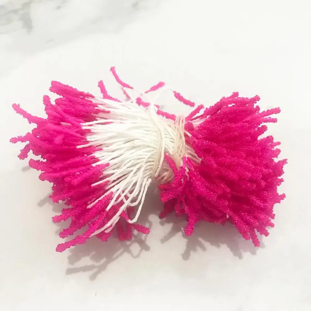 A vibrant pink and white pom-pom hair tie from the 200pcs mixed rose red flower stamen bundle for diy decor