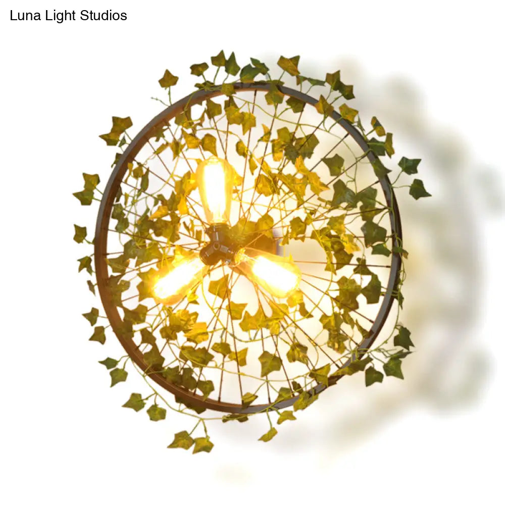 Aplique de pared estilo cabaña de metal negro con tres bombillas y decoración de hojas