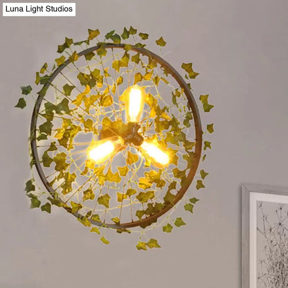 Aplique de pared estilo cabaña de metal negro con tres bombillas y decoración de hojas