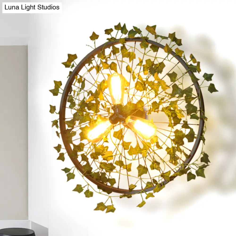 Aplique de pared estilo cabaña de metal negro con tres bombillas y decoración de hojas