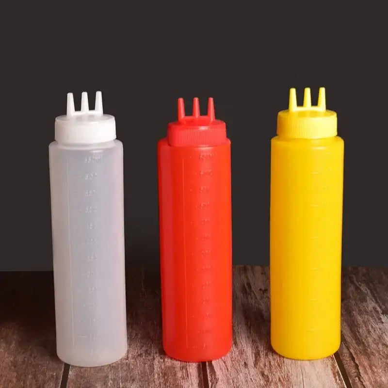 Three plastic squeeze bottles in white red and yellow with three-prong caps for a multi-color squeeze bottle condiment dispenser set