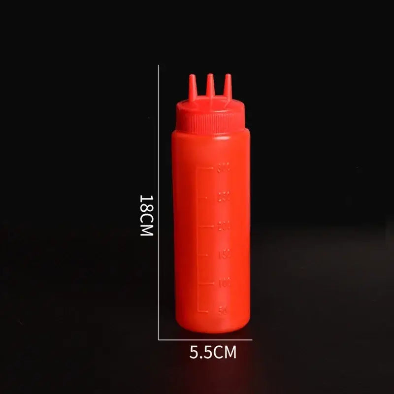 Red plastic squeeze bottle condiment dispenser with three nozzles and measurement markings for kitchen use
