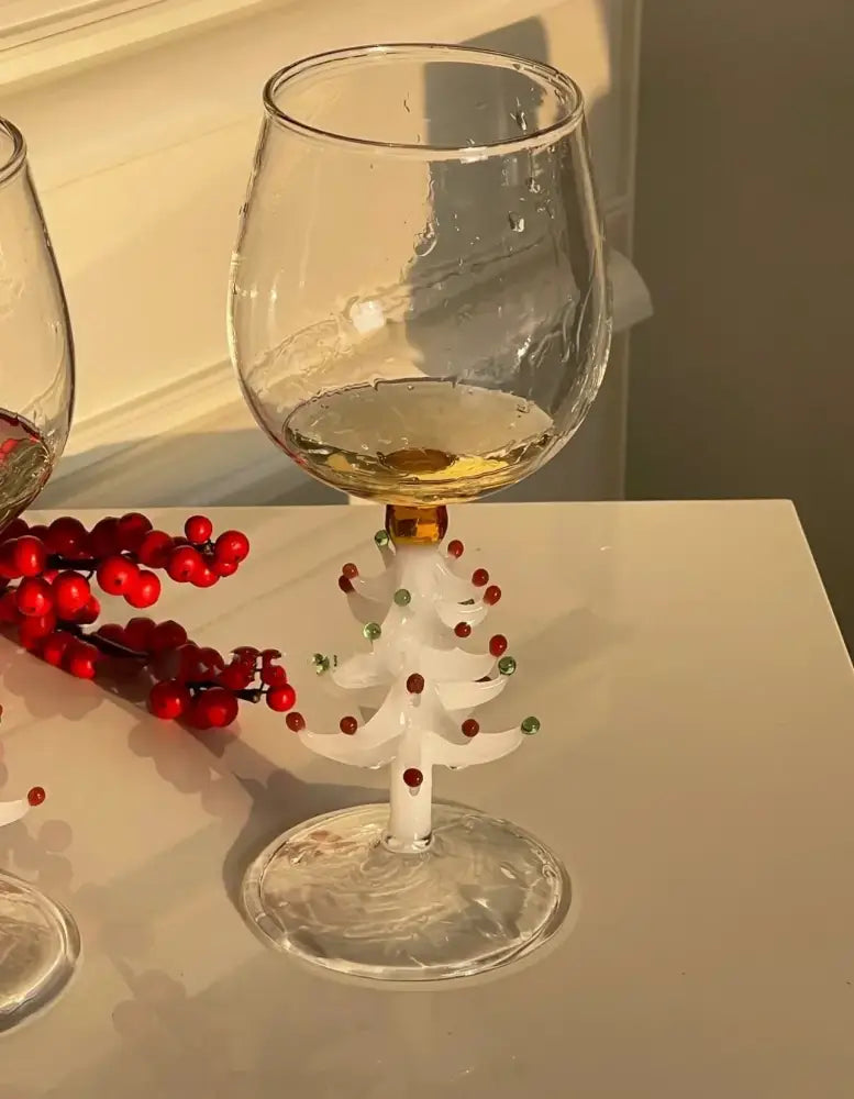A clear glass 300ml 3d christmas tree wine goblet with a white tree stem adorned with red and green beads