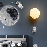Warm glowing spherical wall lamp with dangling astronaut figurine for kids bedroom decorbites astronaut moon wall