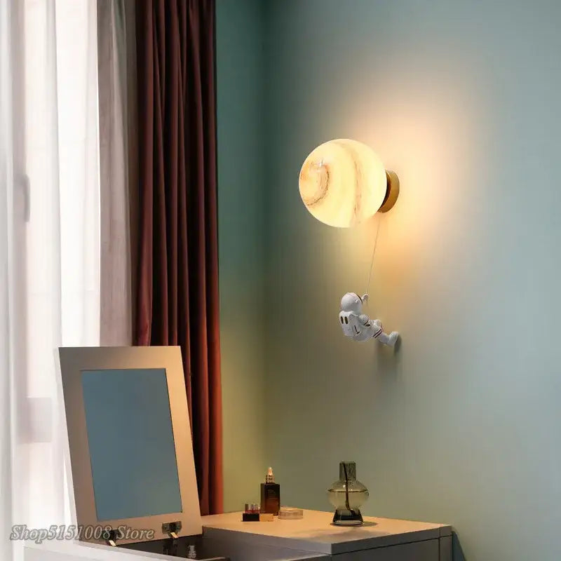 A whimsical white decorbites astronaut moon wall lamp with warm marbled glow for kids bedroom decor