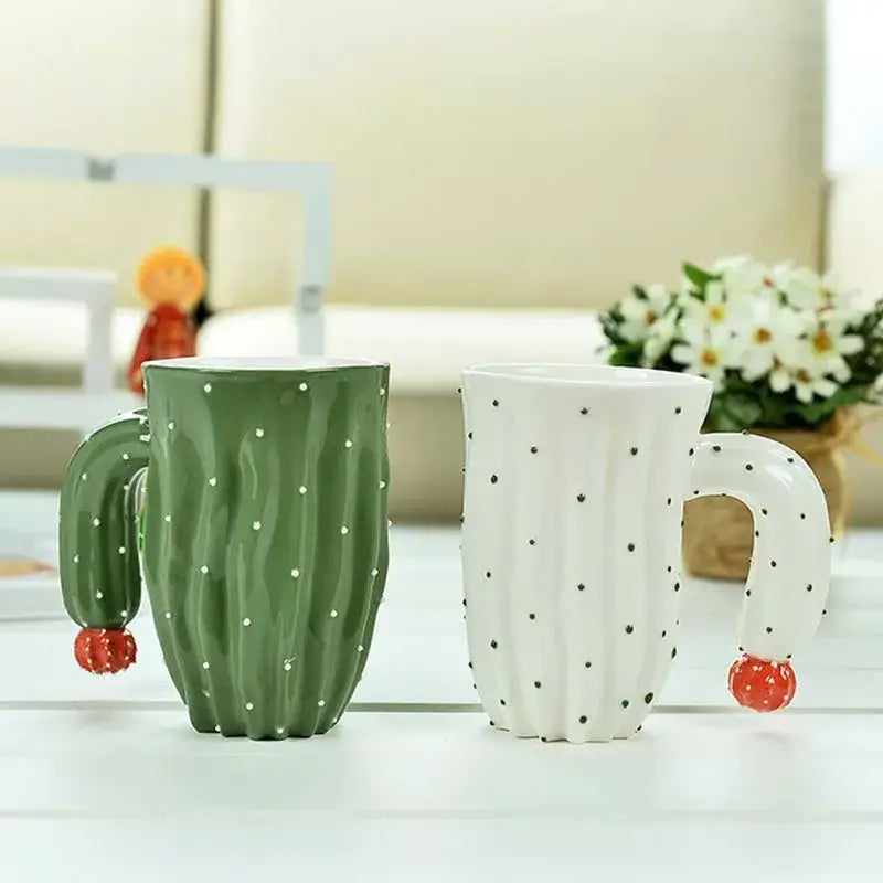 Two decorbites 3d cactus style ceramic mugs in green and white polka dot design with cactus arm handles ending in red berry