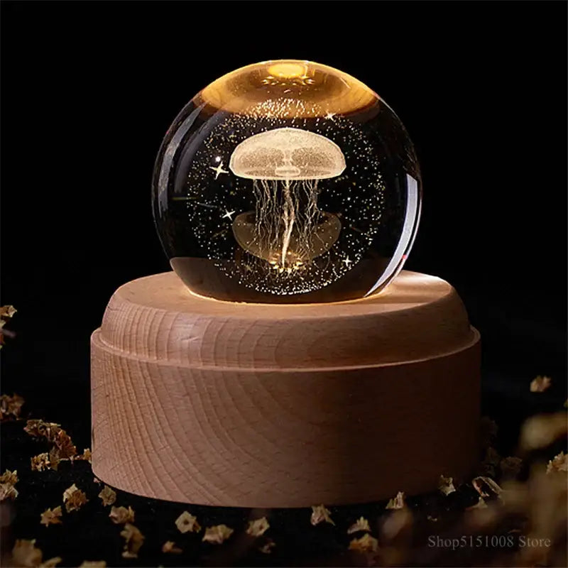 A glowing translucent jellyfish inside a glass decorbites crystal ball night light on a wooden base for bedroom decor