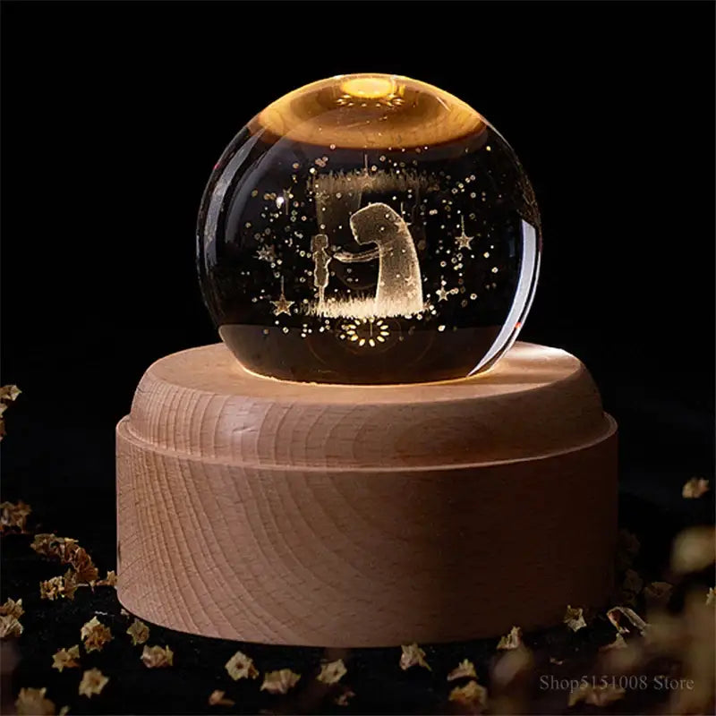A glowing transparent glass night light crystal ball with an engraved figure on a wooden base for decorbites crystal ball night