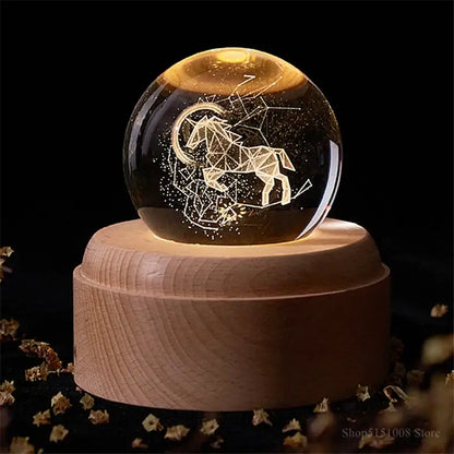 A glowing aries constellation glass sphere night light on a light wooden base decorbites crystal ball night decor