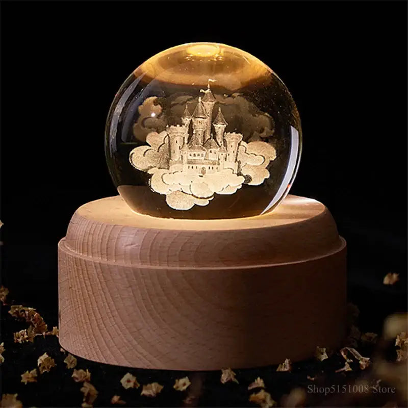 A warm-lit decorbites crystal ball night light with an engraved castle on a wooden music box base for bedroom decor