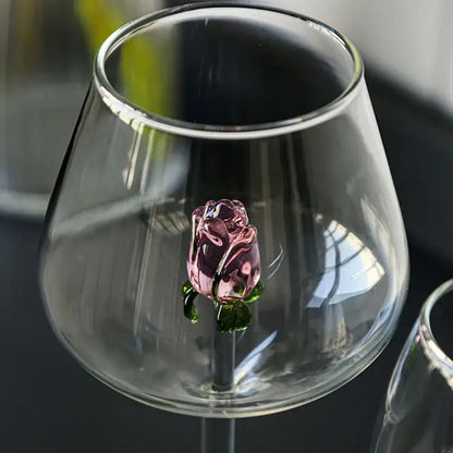 A delicately crafted decorbites 3d pink glass rose with green leaves inside a clear glass rose wine goblet