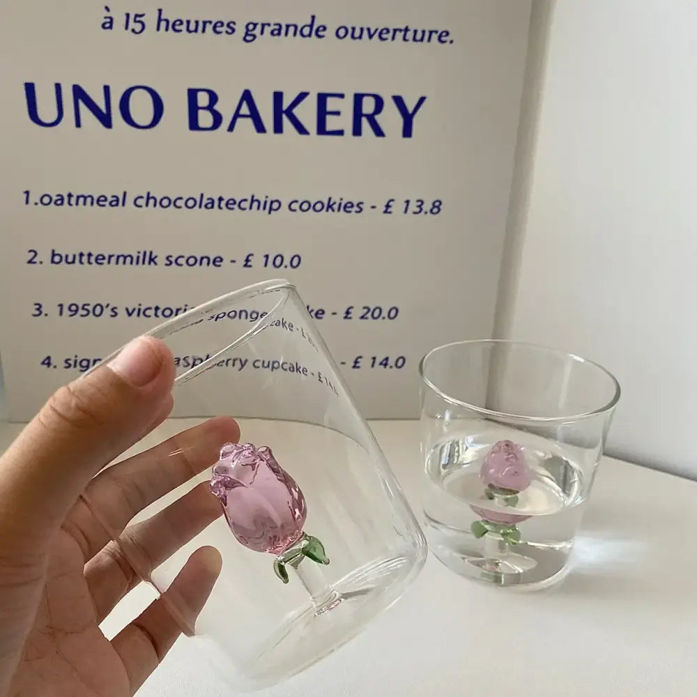 A clear modern champagne flute with a delicate pink glass decorbites 3d rose ornament at the base