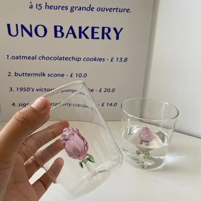 A clear modern champagne flute with a delicate pink glass decorbites 3d rose ornament at the base