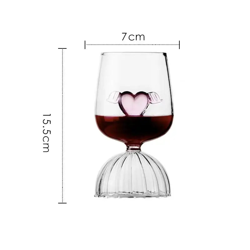 A clear glass 3d rose champagne flute with pink heart ornament and red liquid on a fluted base for decorbites rose