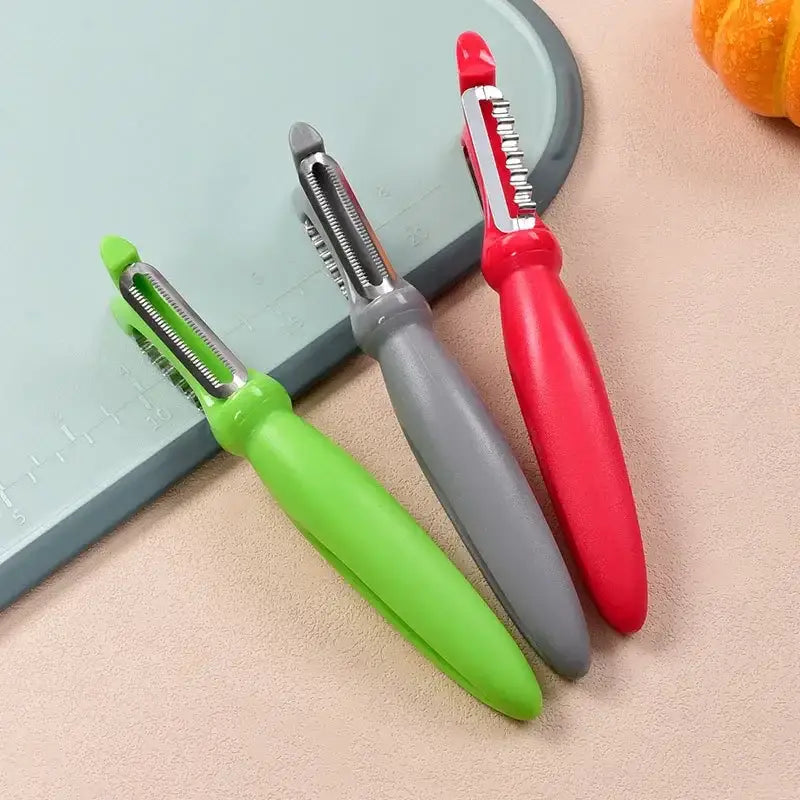 Three colorful stainless steel vegetable peelers with ergonomic handles in green gray and red from a 5 piece set