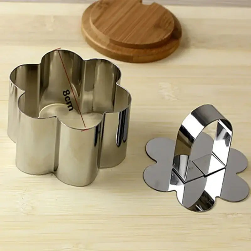 Shiny stainless steel flower-shaped cookie cutter with matching handle from 9 piece stainless steel bakeware mold set