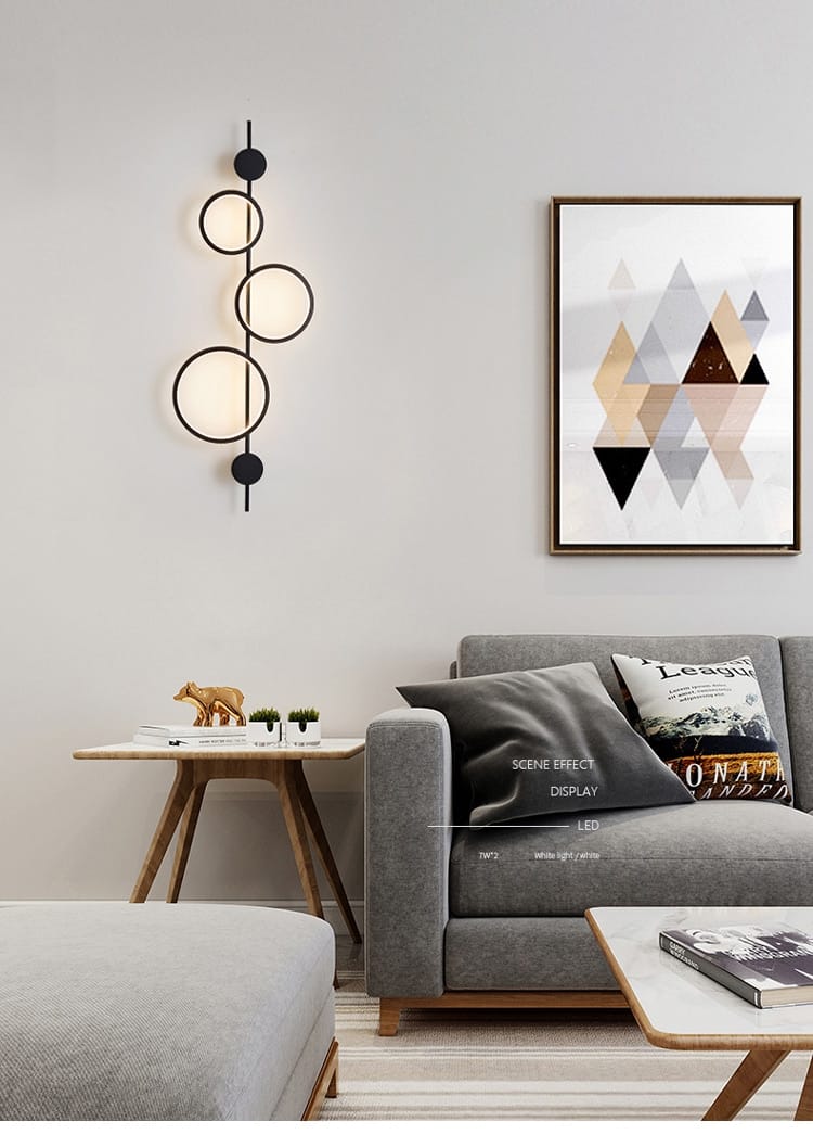Modern black linear long led wall light featuring a black circular wall sconce with three illuminated rings and matte black accents for living room use.