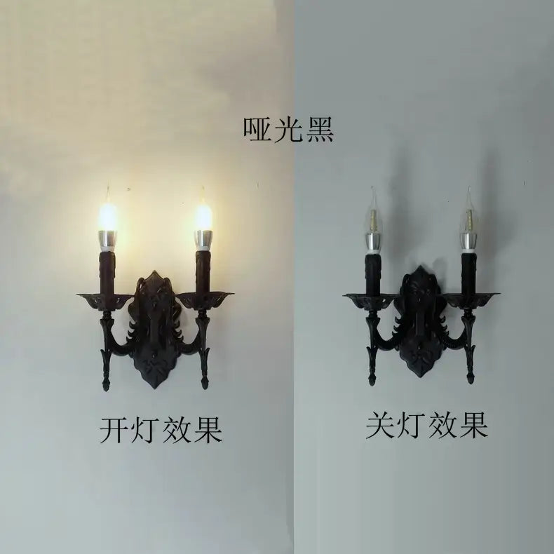 Matte black wrought iron two-light wall sconce with ornate scrollwork and candle-style bulbs featured as a creative retro European wall light for bedroom use.