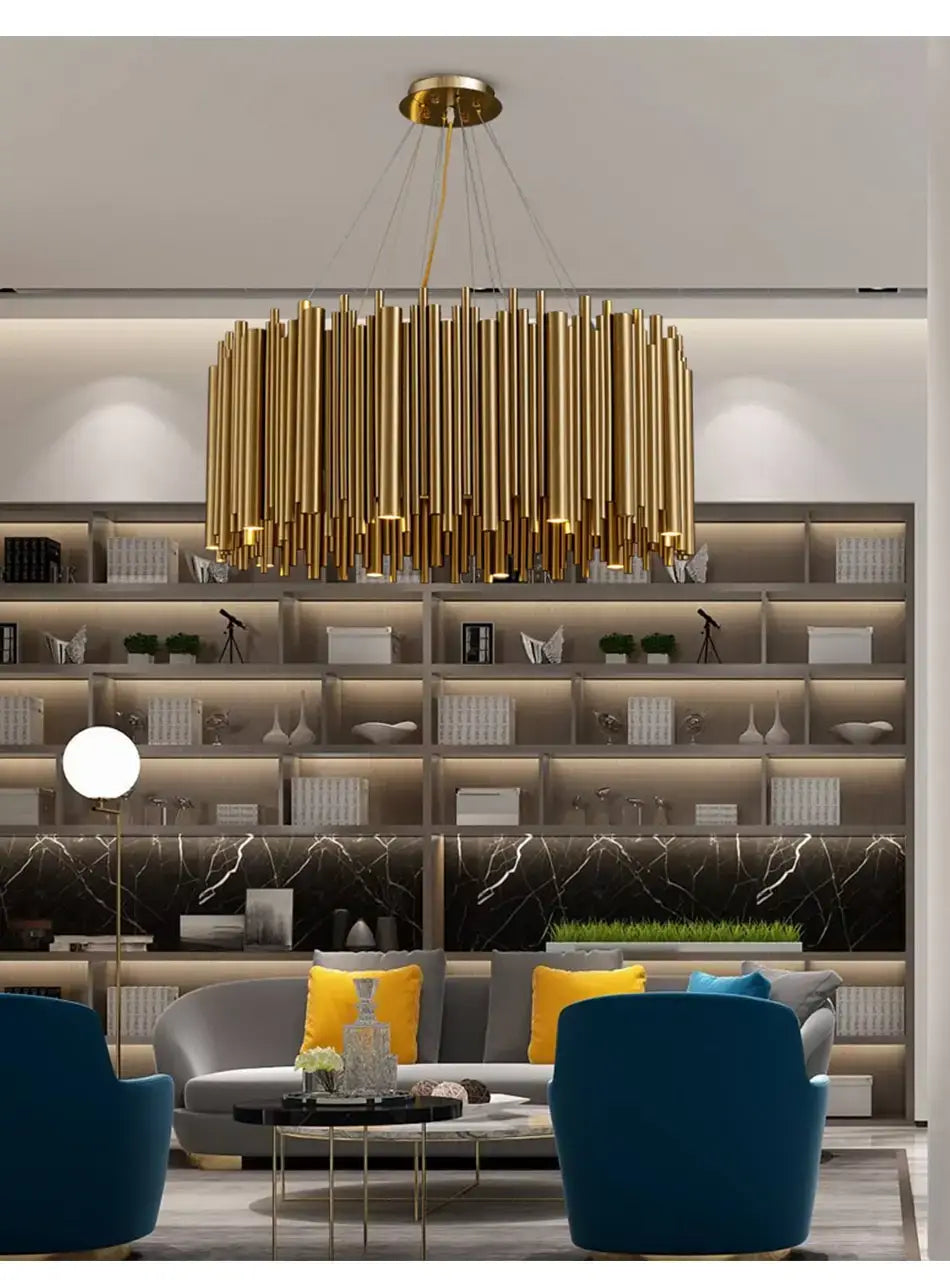 Luxury modern round gold chandelier with a sculptural design featuring golden cylindrical elements hanging in a living room interior.