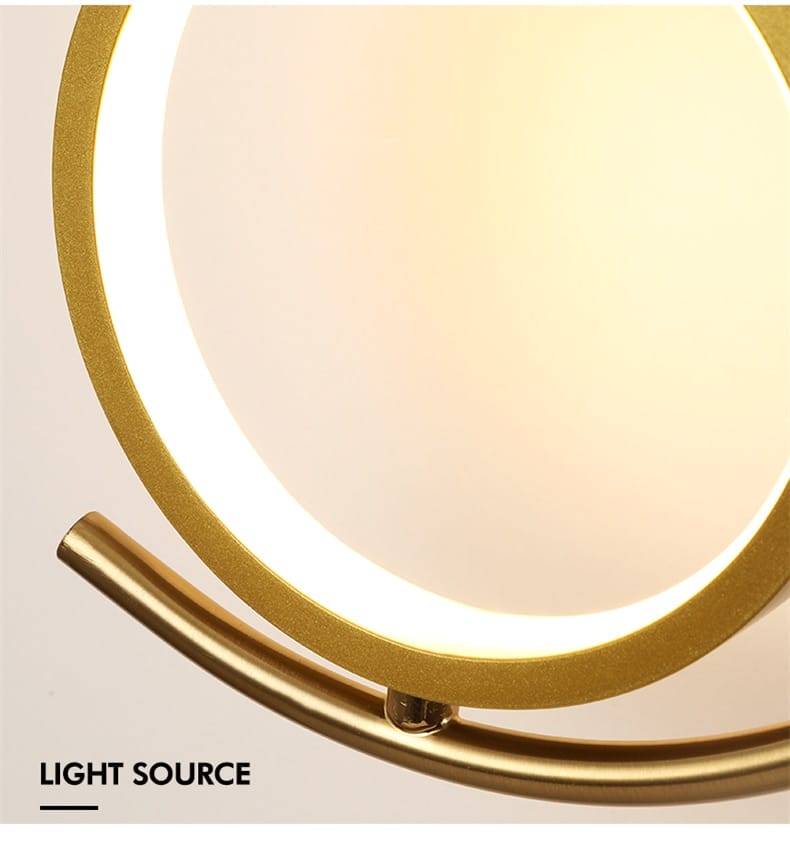 Modern gold luxury creative led circular vanity mirror with an illuminated led ring designed as a creative led bedside wall lamp for bedroom use.