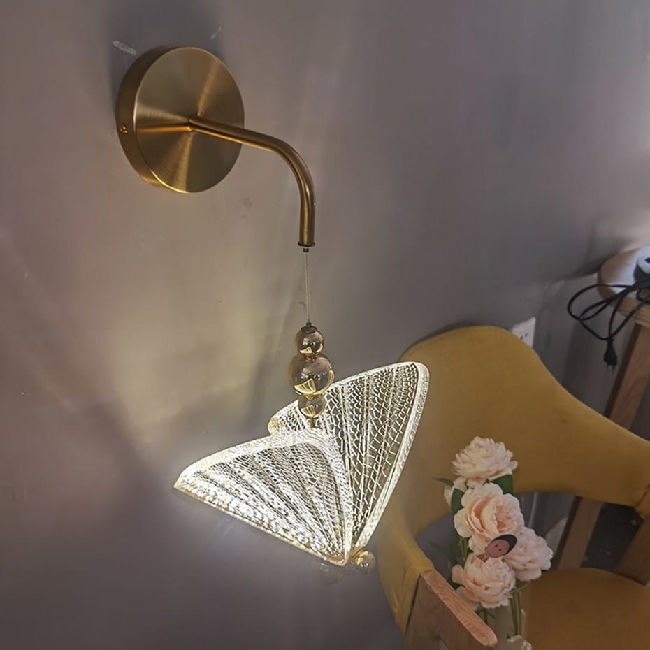 gold-toned nordic butterfly led wall light featuring a delicate illuminated butterfly-shaped crystal shade designed for bedroom use.
