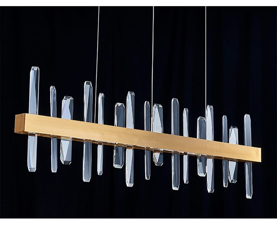 Modern rectangle gold crystal chandelier featuring clear faceted prisms hanging vertically from thin wires for dining room lighting.