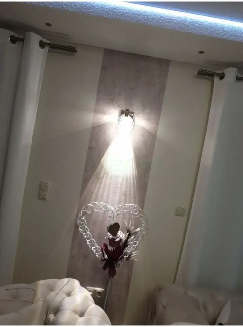 modern gold crystal led wall lamp featuring a silver heart-shaped decorative light fixture with a central dark floral arrangement for bathroom use